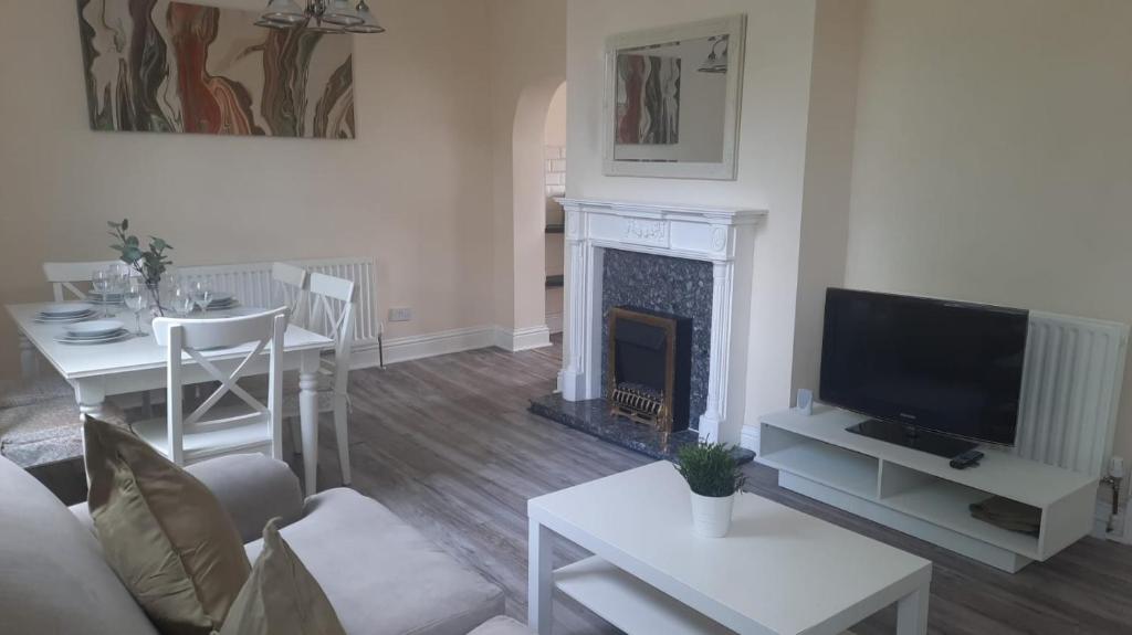 a living room with a tv and a fireplace at Alexander Apartments City North in Newcastle upon Tyne