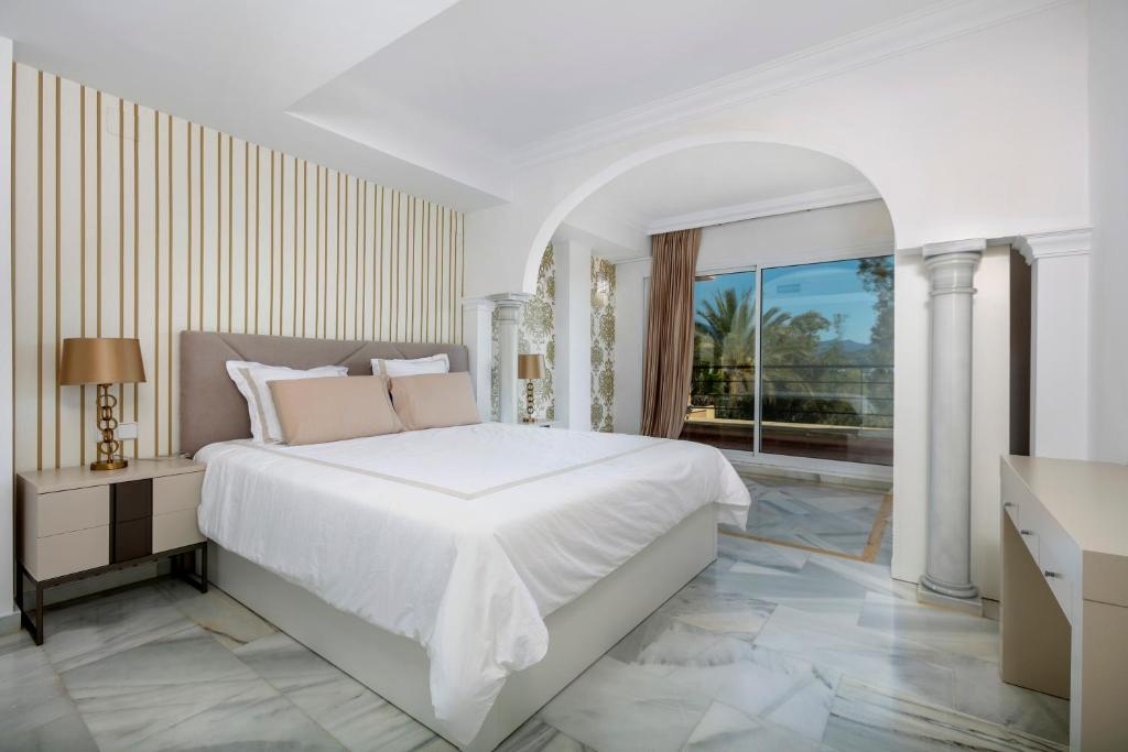 1 dormitorio con cama blanca y ventana grande en Stunning 2 bedroom apartment Magna Marbella RDR259, en Marbella