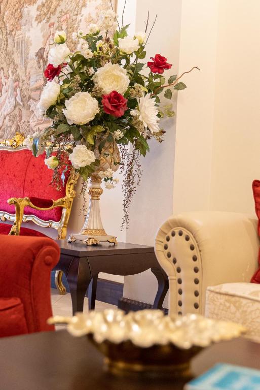 a vase filled with red and white flowers on a table at Hotel Boutique Casa Veracruz in Estepona