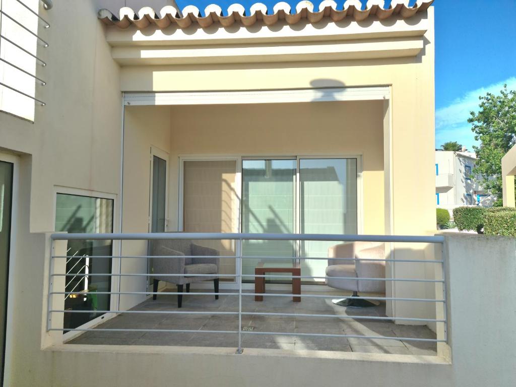 een balkon met twee stoelen en een tafel bij Varandas do Carvoeiro in Carvoeiro