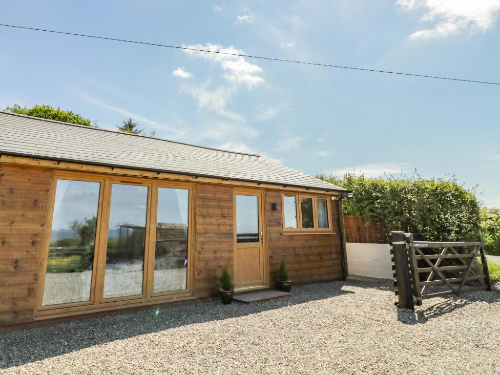 a wooden cabin with glass windows and a fence at Fairfield in Ludlow