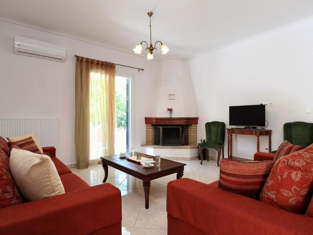 a living room with two red couches and a tv at Frida's House in Kariá