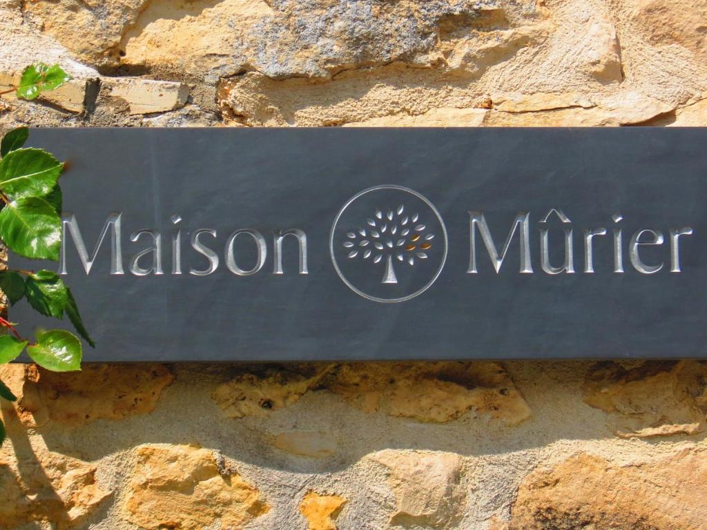 ein Schild für das Spiegelmuseum an einer Steinmauer in der Unterkunft La Maison Mûrier in Chef-Boutonne