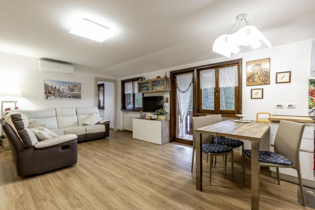 ein Wohnzimmer mit einem Sofa und einem Tisch in der Unterkunft Des Alpes 2 in Canazei