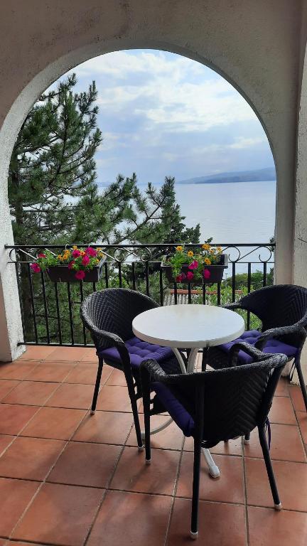 a patio with a table and chairs and the ocean at Vlatković in Senj