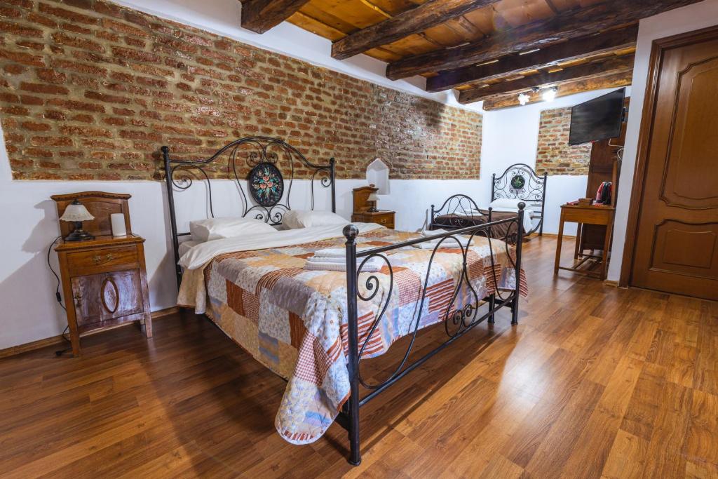 a bedroom with a bed and a brick wall at Chalet Giuel in Bărcuţ