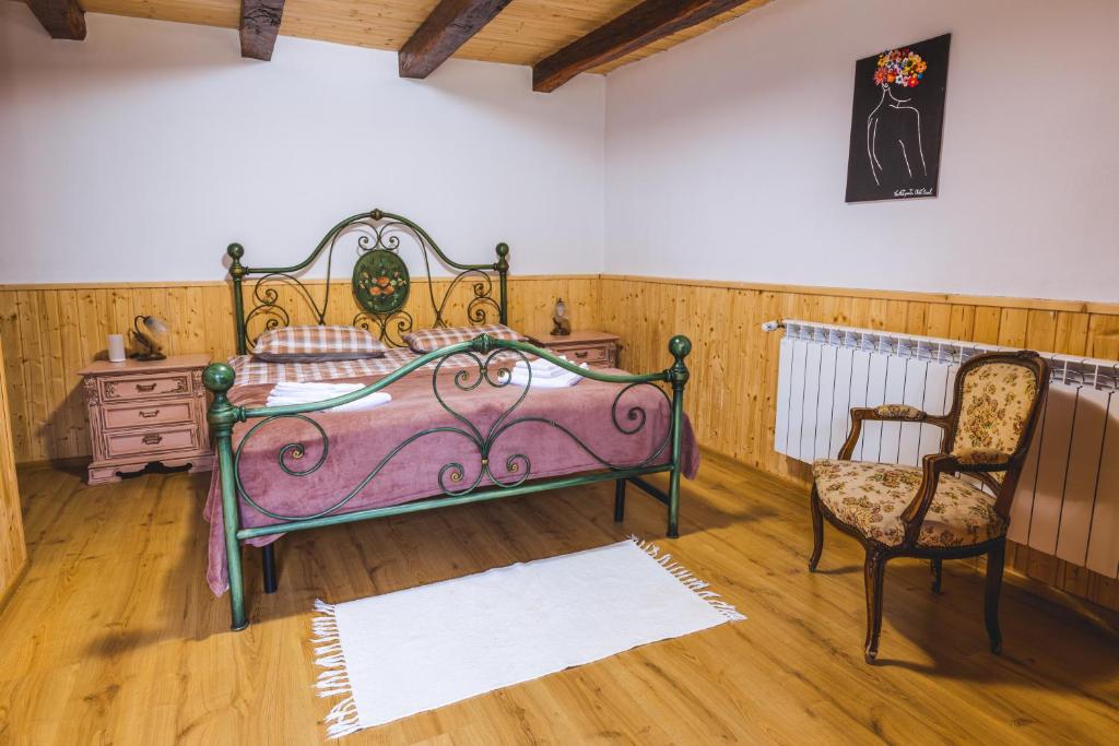 a bedroom with a pink bed and a chair at Chalet Giuel in Bărcuţ