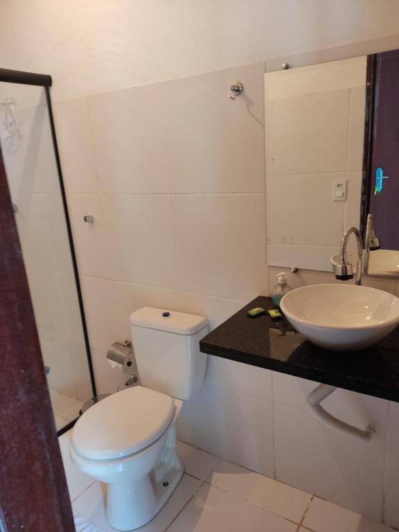 a bathroom with a white toilet and a sink at Pousada Céu Azul in Sao Jorge