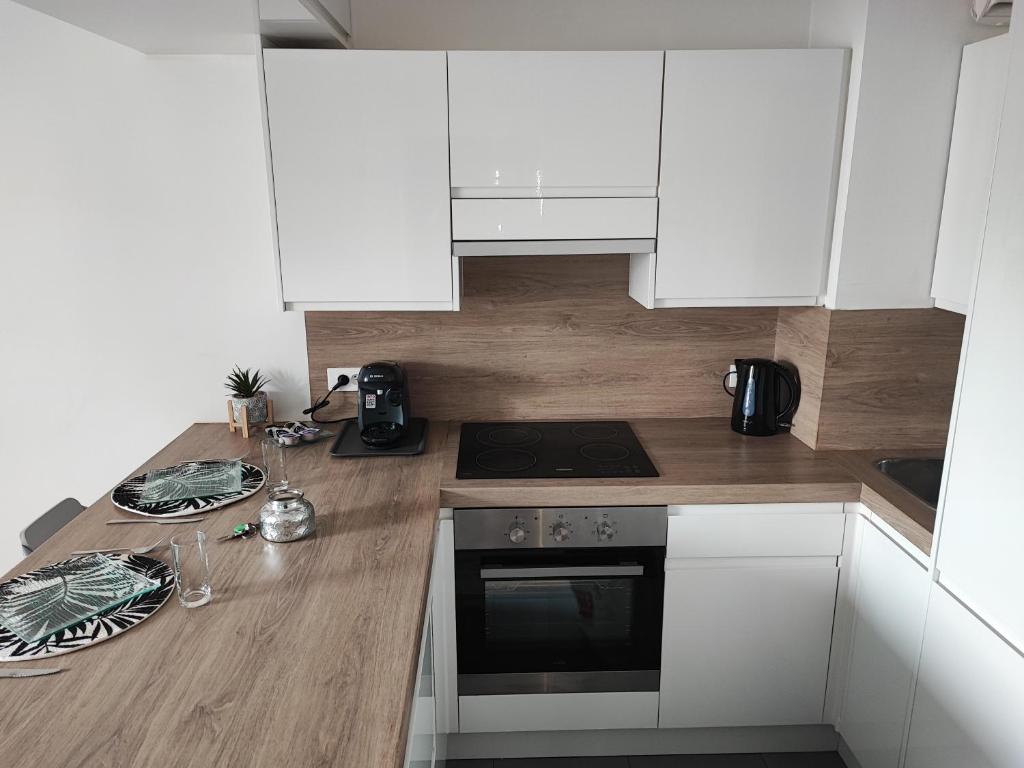 a kitchen with white cabinets and a wooden counter top at Chic et moderne+Wifi+Netflix in Argenteuil