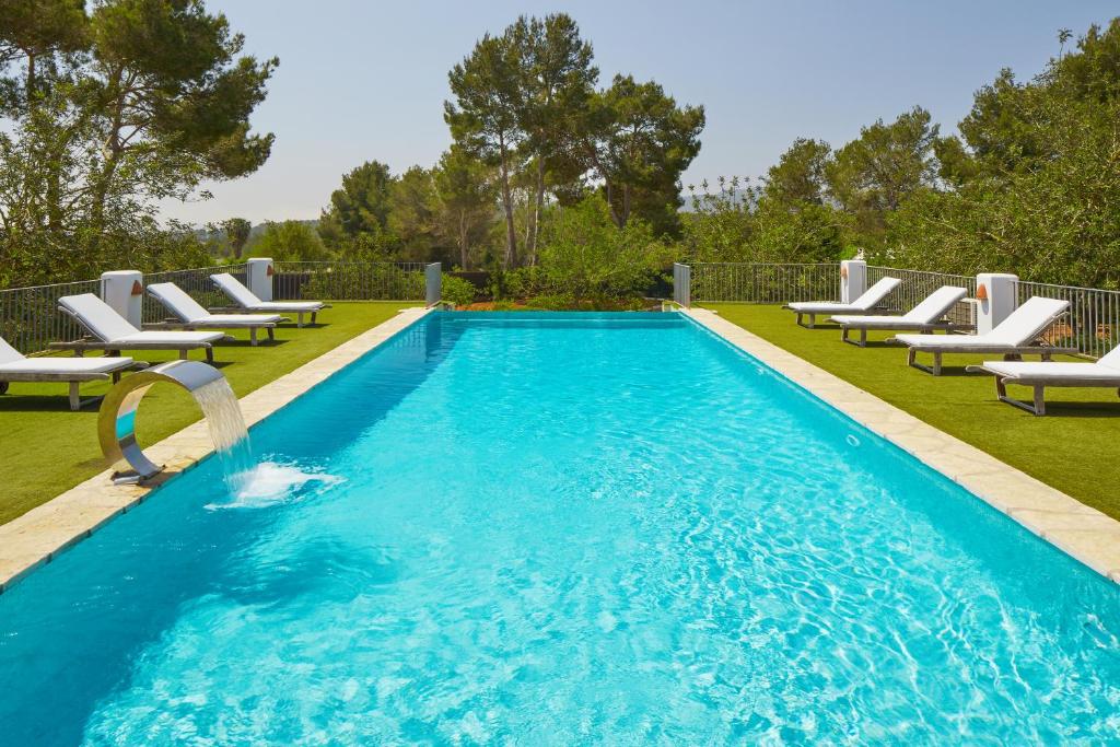 a swimming pool with chaises and chairs in a yard at Villa Munt Blanc Ibiza in Puig D’en Valls
