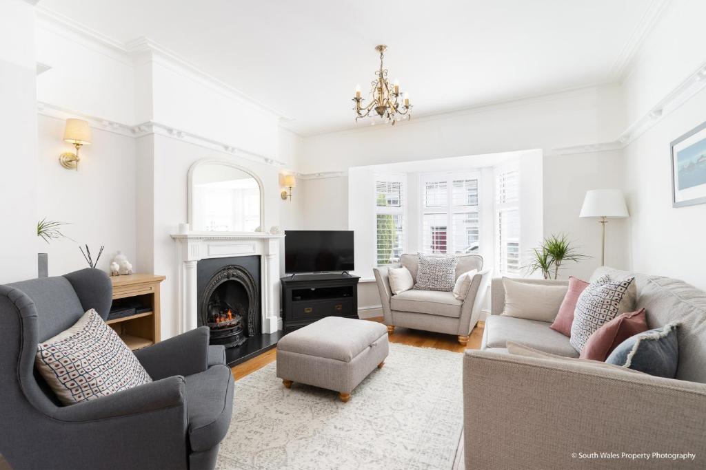 a living room with two couches and a fireplace at 6 Woodville in The Mumbles