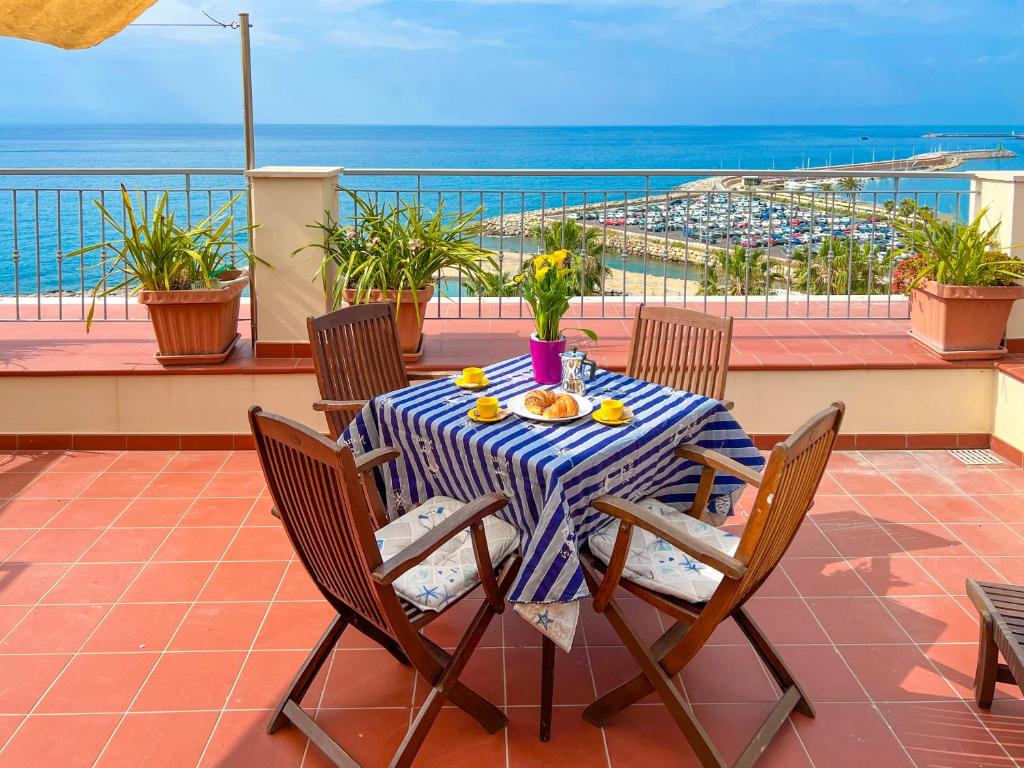 a table on a balcony with a view of the ocean at Vista Mare Borgo Peri in Imperia