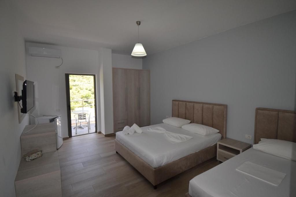 1 dormitorio con 2 camas y TV. en Bujtina Eleni, en Himare