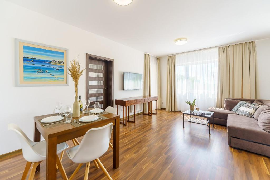 ein Wohnzimmer mit einem Tisch und einem Sofa in der Unterkunft Apartament Atrium 115 Visit Baltic in Sarbinowo