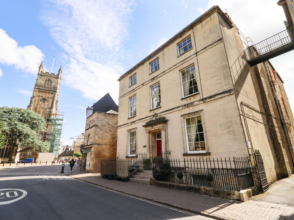 an old building on a street with a clock tower at Dollar Ward House Basement in Cirencester