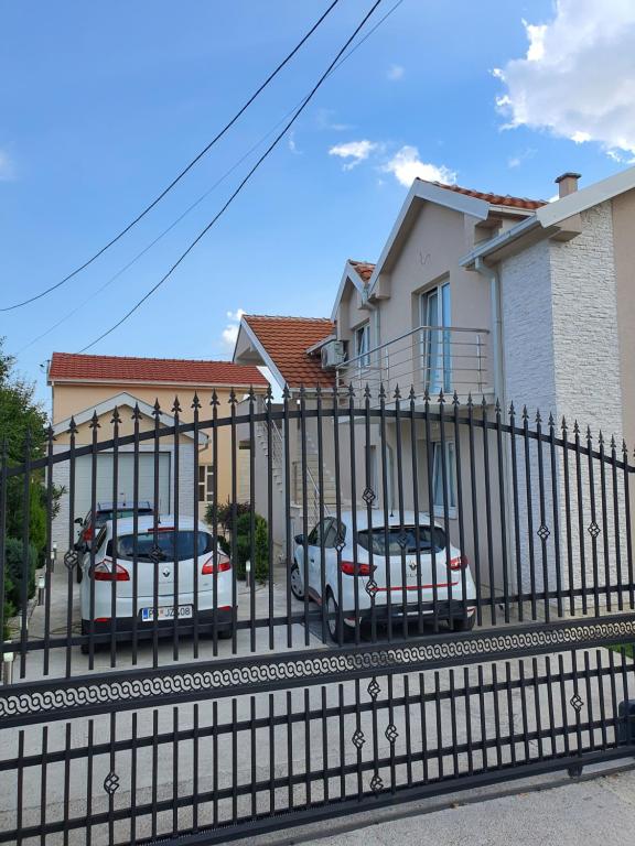 een zwart hek met auto's geparkeerd voor een huis bij Apartman Tolosi 2 in Podgorica
