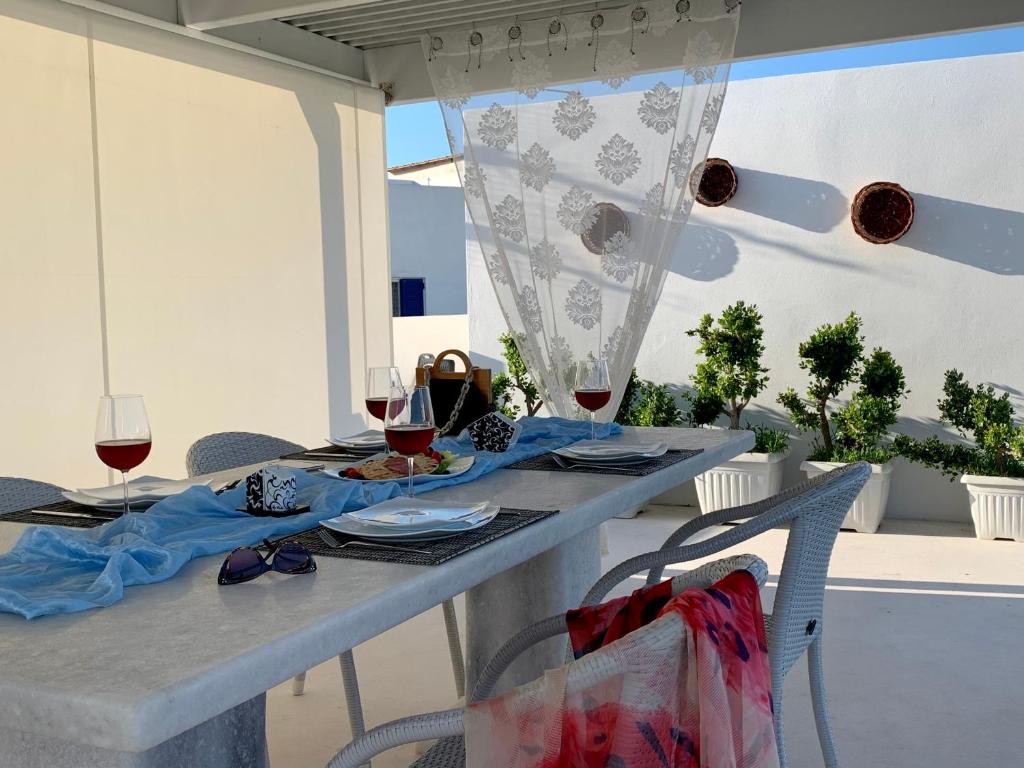 a table with glasses of red wine on it at PORTA HOME modern and hospitable in Naxos Chora