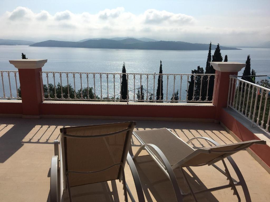 a balcony with a chair and a view of the water at Villa Aliki in Ágios Stéfanos