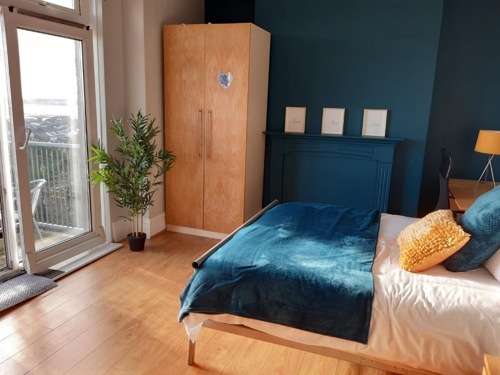 a bedroom with a bed with a blue blanket on it at Swansea Townhouse Perfect for contractors Private double rooms in Swansea