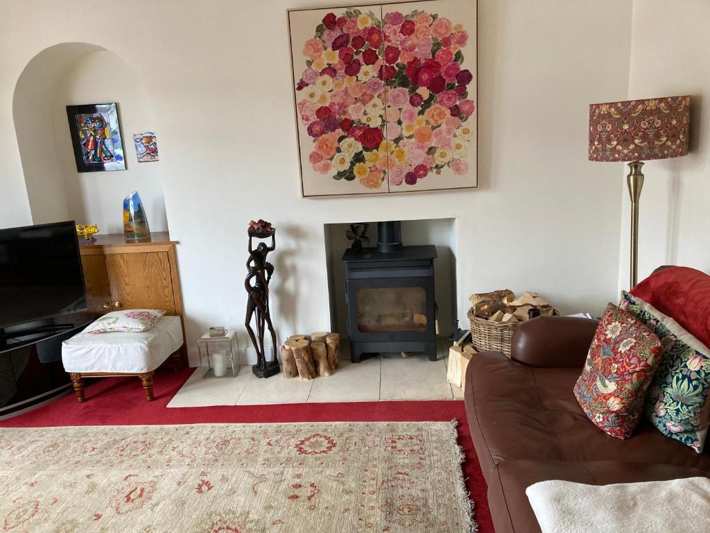 sala de estar con sofá y chimenea en Rose Cottage, en Prestwick