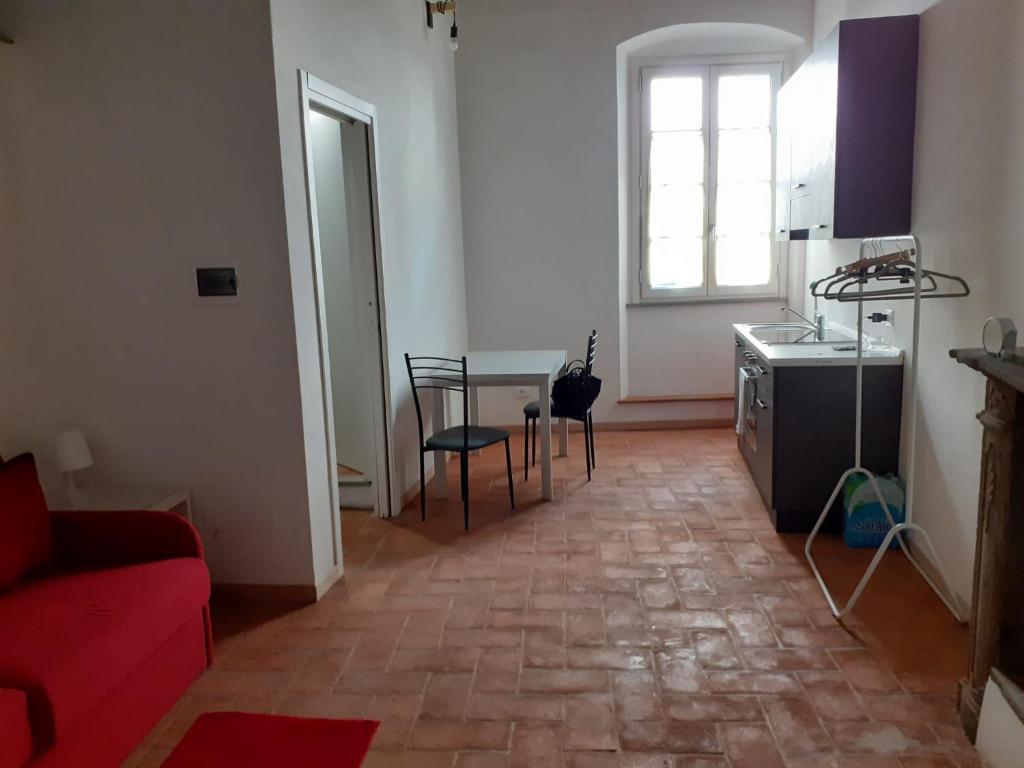 een woonkamer met een rode bank en een tafel bij Il caminetto in Peccioli