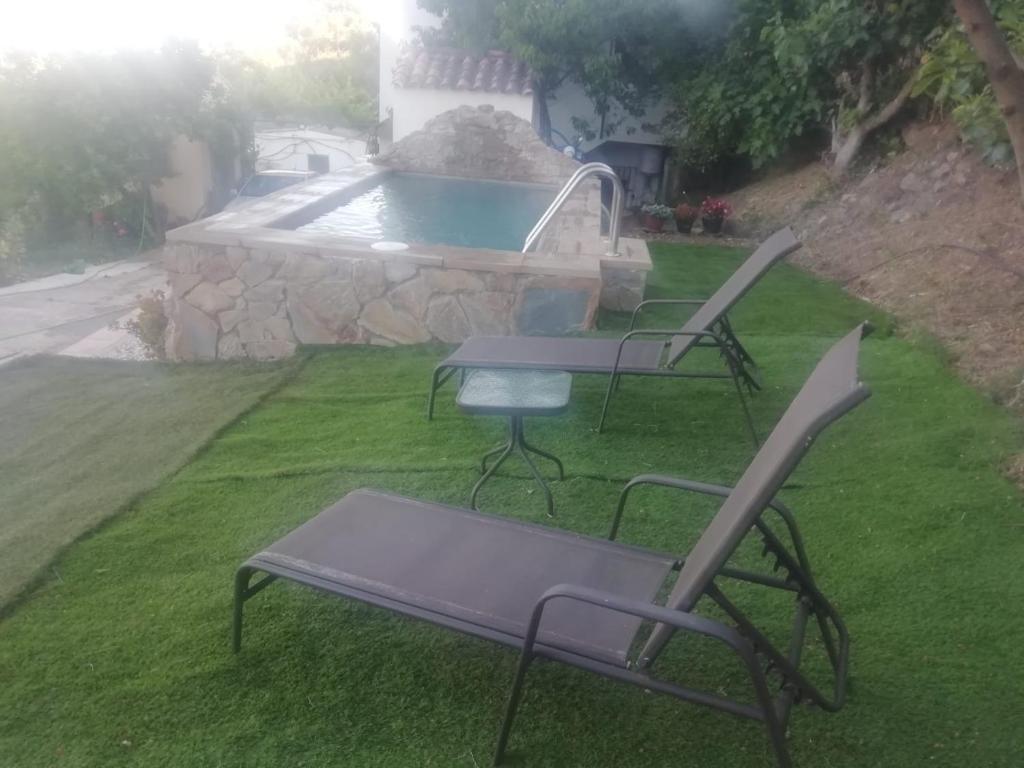 a group of chairs and a table and a pool at Casa el Pino in Cortes de la Frontera