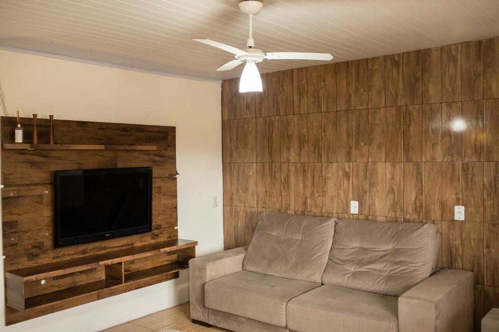 a living room with a couch and a flat screen tv at TOLEDO'S HOUSE in São Francisco de Paula