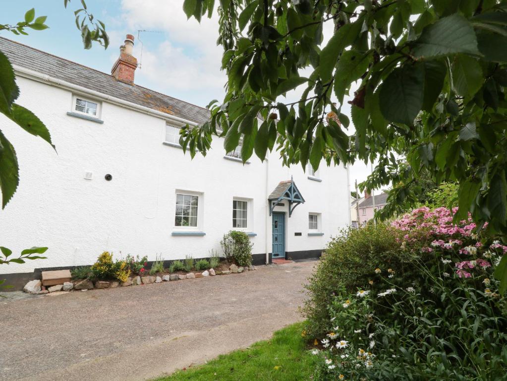 a white house with a driveway in front of it at 1 Castle Cottages in Exeter