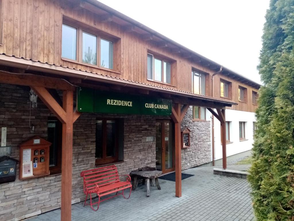 a building with a red bench in front of it at Apartmán v Lipně nad Vltavou 25 in Lipno nad Vltavou