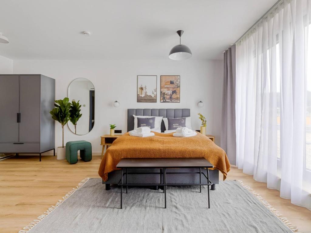 a bedroom with a bed with an orange blanket on it at limehome Bodenmais Bahnhofstraße in Bodenmais