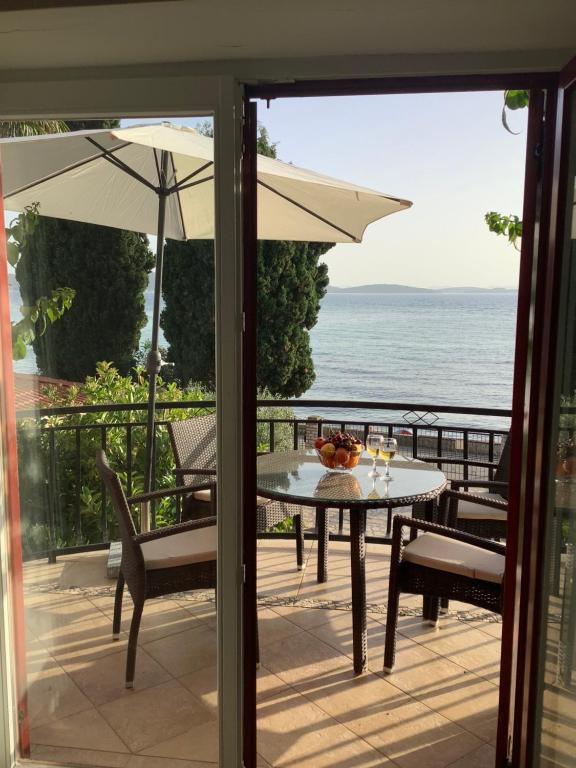 a table and chairs on a balcony with a view of the ocean at Apartments Plazs 41 in Sukošan