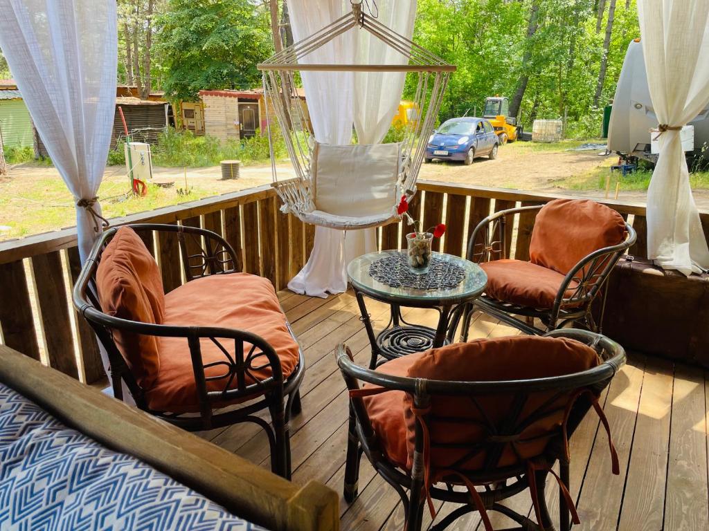 a porch with chairs and a table on a deck at Караваната На Морето in Sozopol