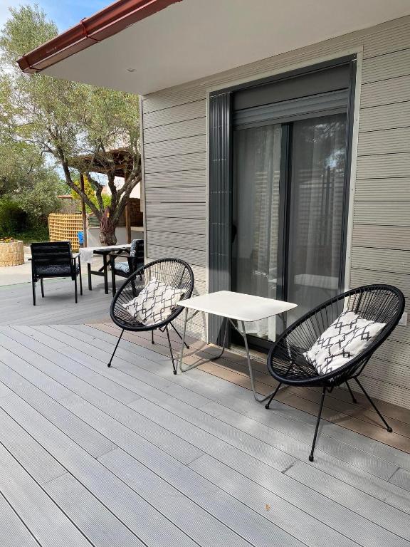 two chairs and a white table on a deck at Villa Elea in Vourvourou