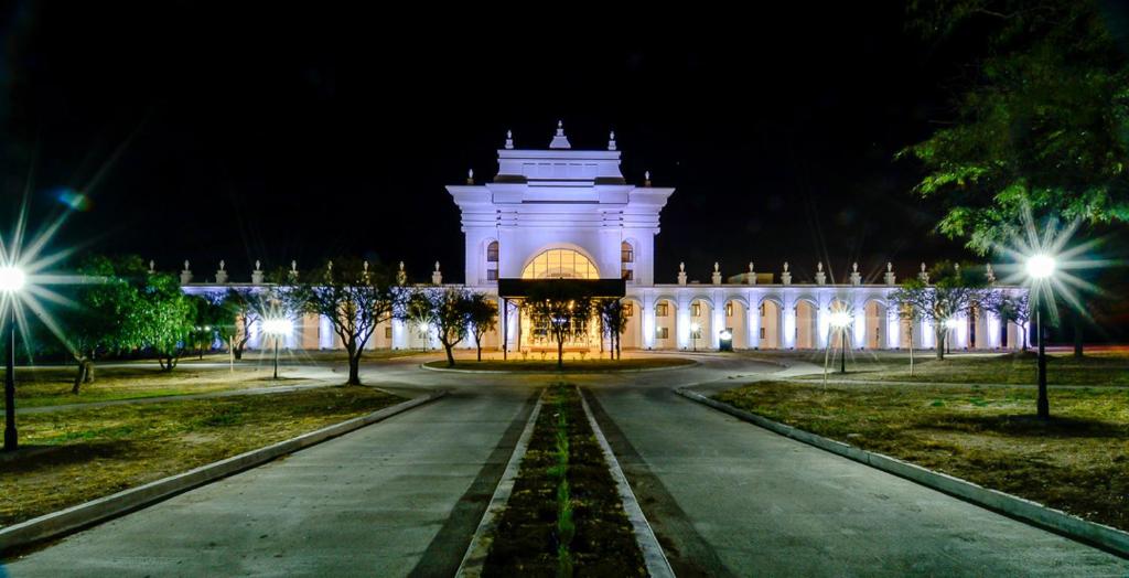 a large white building at night with lights at La Recova Hotel & Spa in La Punta