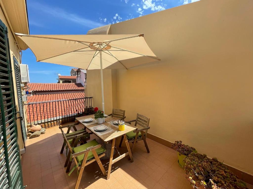 een patio met een tafel en een parasol bij Mirèa Apartment a Cefalù in Cefalù