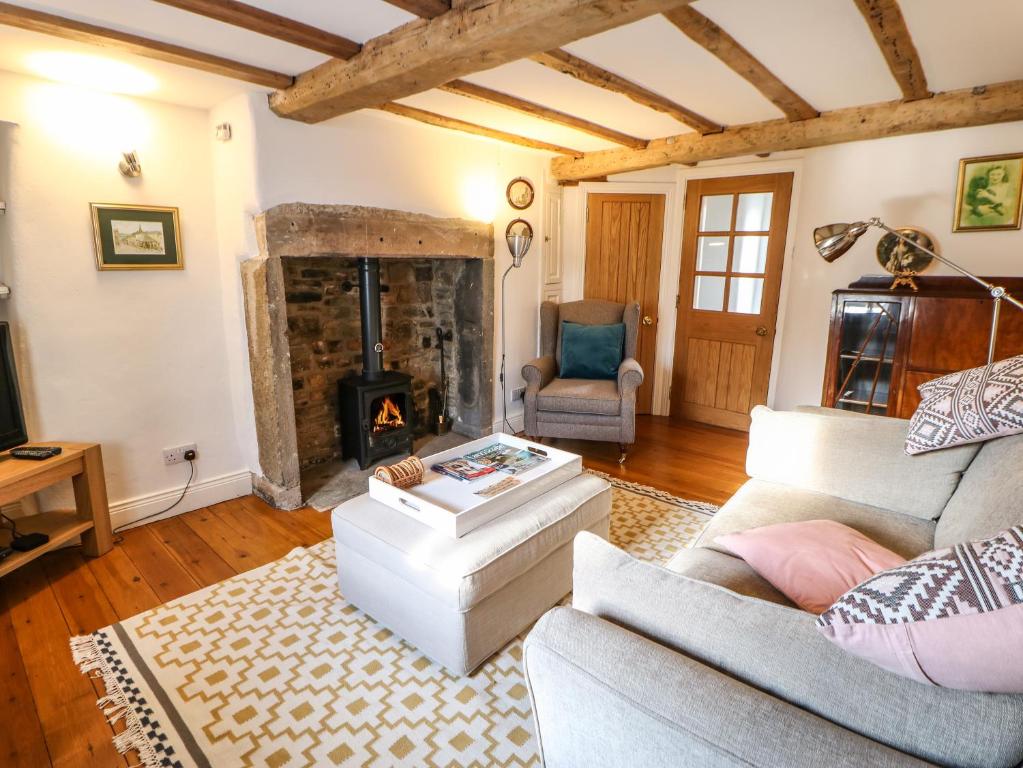 un soggiorno con divano e camino di Cross View Cottage ad Alston