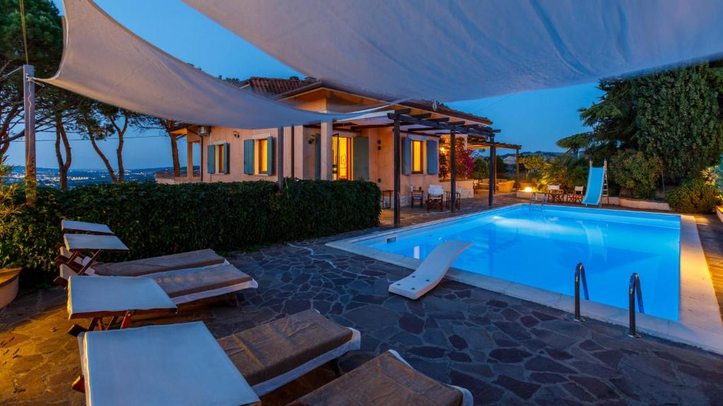 una piscina con sillas y una casa en Villa delle Rose - Modern design, pool & AirCO, en Colbordolo