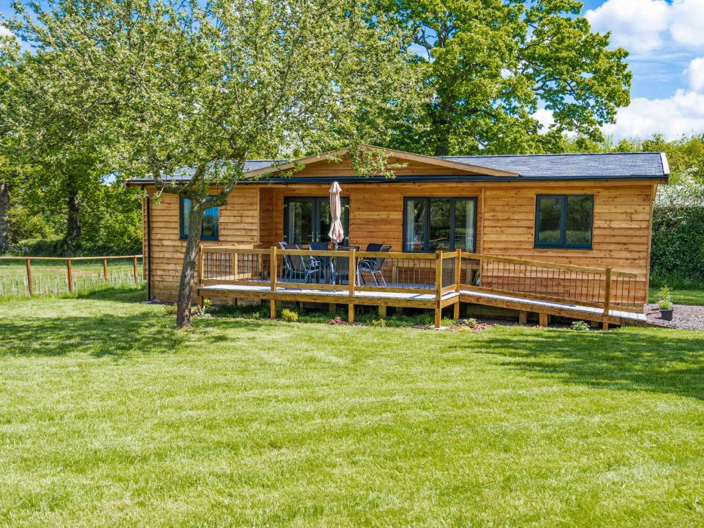 a log cabin with a large deck in the yard at Top Style Orchard in Worcester