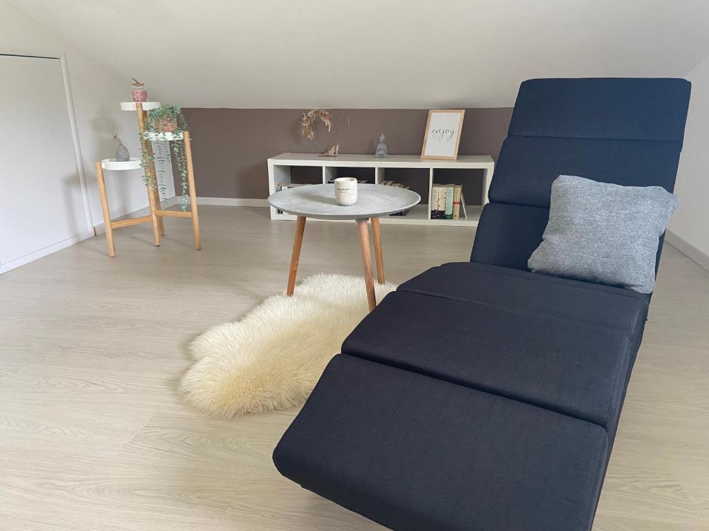 uma sala de estar com uma cadeira azul e uma mesa em Ferienwohnung Burgzauber em Kastellaun