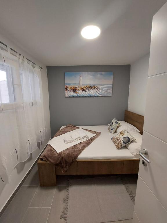 een slaapkamer met een bed met een foto aan de muur bij Apartman Karla in Jadrija