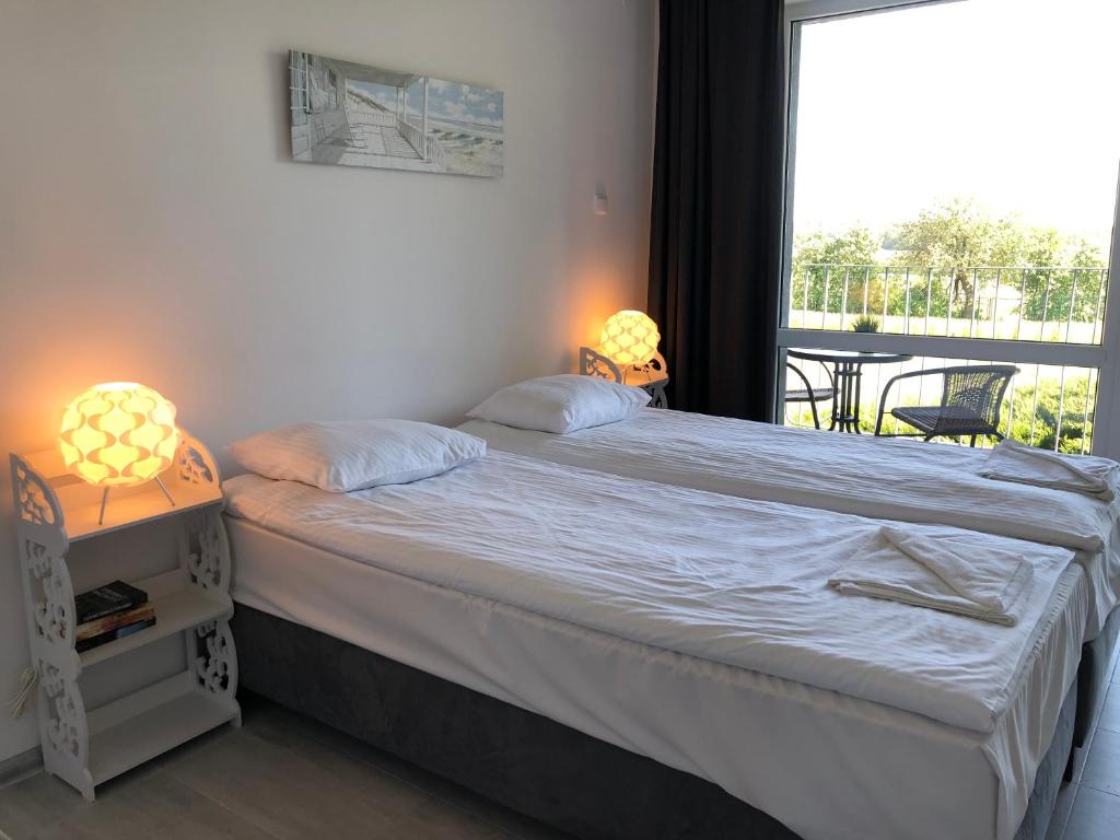 um quarto com uma cama e uma grande janela em Sea Power Horyzont Apartament 9 em Jastrzebia Gora