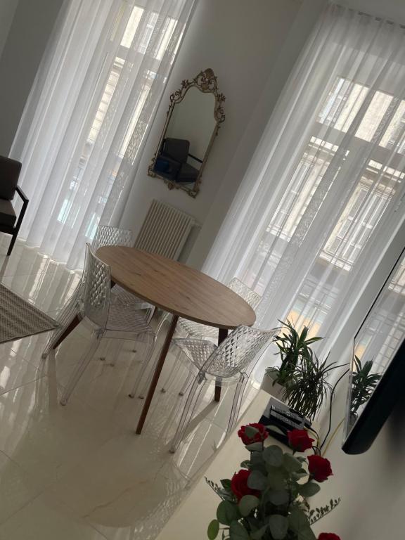 une table et des chaises dans une pièce avec des fenêtres dans l'établissement Le Splendid NICE centre Ville, à Nice