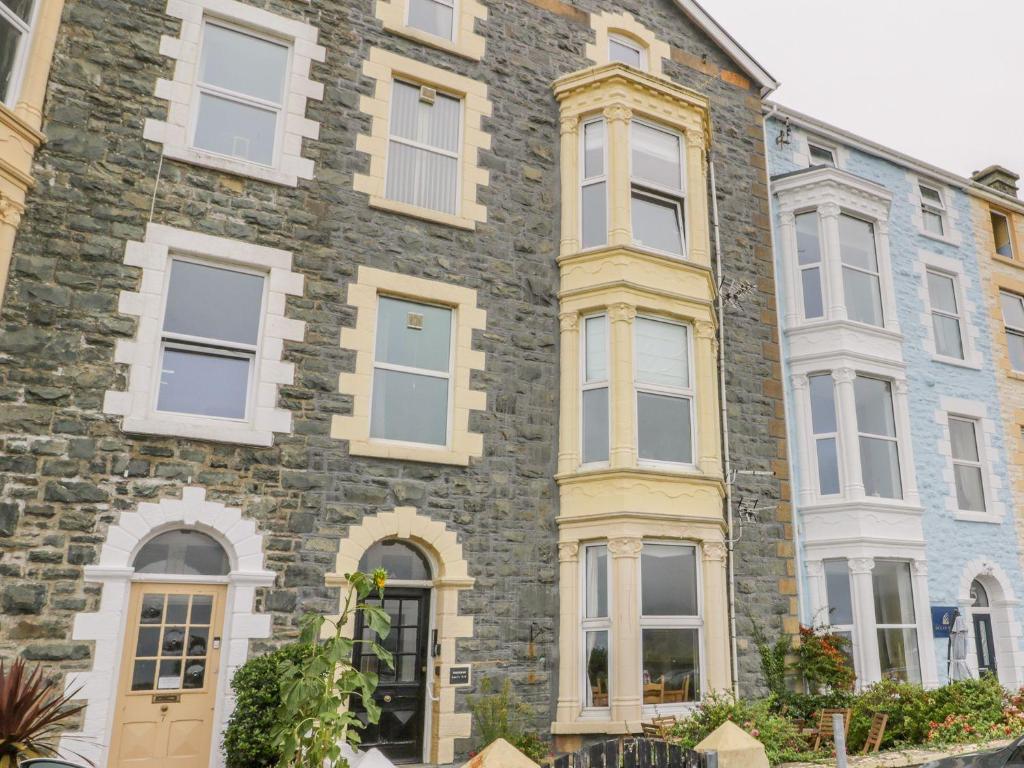 a large brick building with white windows at Sandpiper Apartment in Barmouth