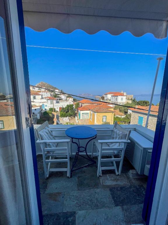 stół i krzesła na balkonie z widokiem w obiekcie Zoe Apartments No 6 , Hydra Island Greece w mieście Hydra