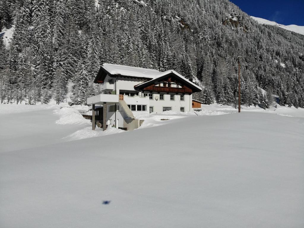 a building in the snow in front of a mountain at Sonnenhof in Niederthai