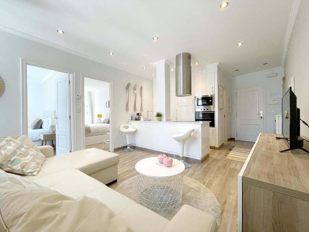 sala de estar con sofá blanco y mesa en Precioso piso nuevo dentro del recinto amurallado en Lugo