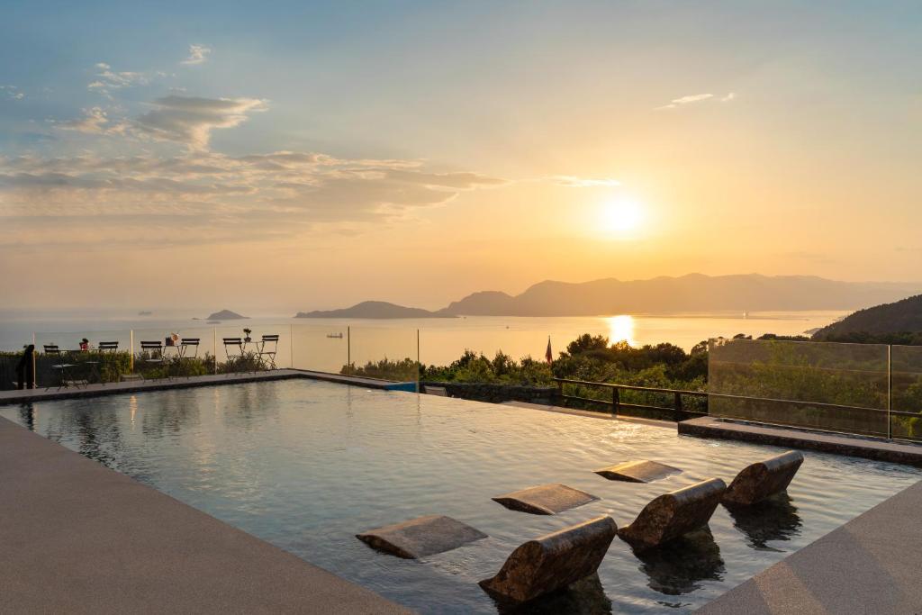 a swimming pool with a sunset in the background at Golfo dei Poeti Relais & Spa in Ameglia
