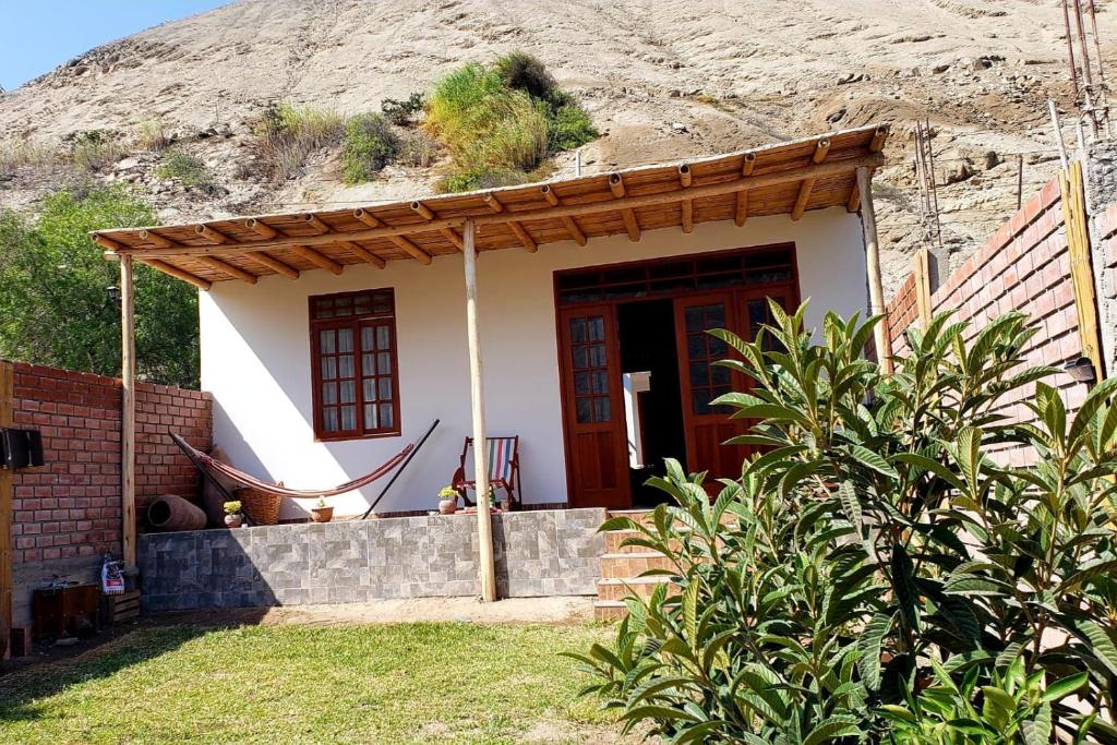mały dom z hamakiem przed nim w obiekcie Lunahuaná CASA DE CAMPO PAULLU w mieście Lunahuaná