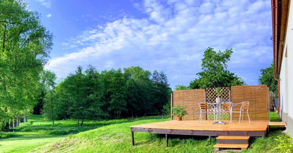a wooden deck with two chairs and a table at Apartmány u řeky Nežárky in Lasenitz