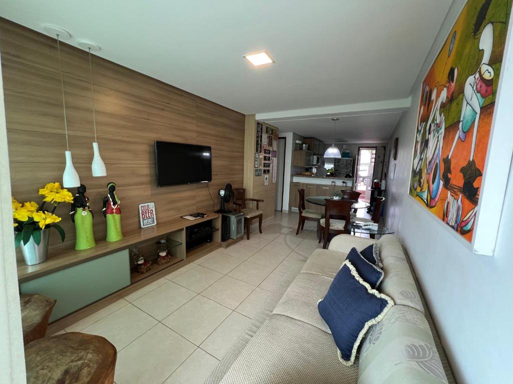a living room with a couch and a tv at Flat 301 Condominio Villa Hipica - Gravatá, PE in Gravatá